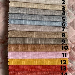 May include: A swatch card with 16 different fabric samples. The samples are arranged in rows, with each row numbered 1 through 16. The fabrics are a variety of colors and textures, including beige, brown, gray, blue, pink, yellow, orange, red, and green.