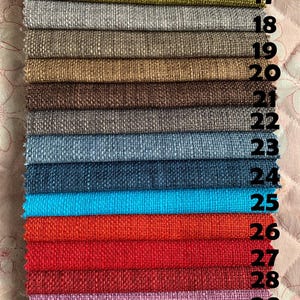 May include: A close-up of 15 fabric swatches in various colors and textures, numbered 16 through 30. The swatches are arranged vertically, with the top swatch being green and the bottom swatch being pink.