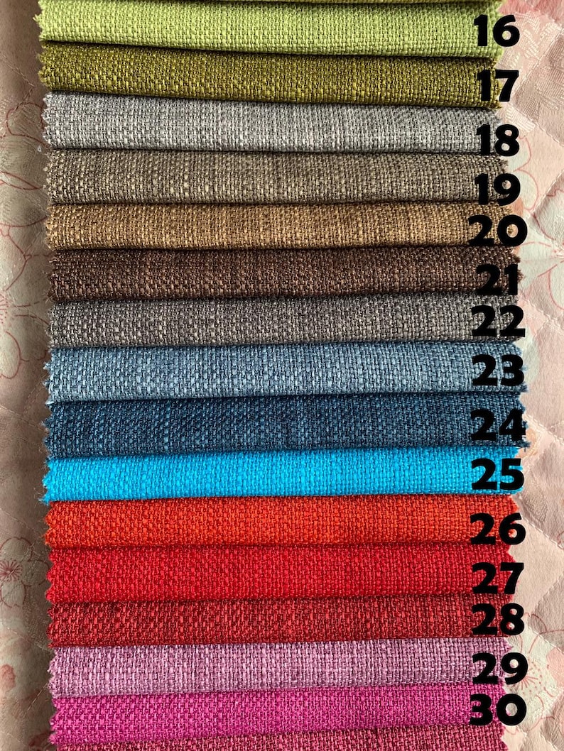 May include: A close-up of 15 fabric swatches in various colors and textures, numbered 16 through 30. The swatches are arranged vertically, with the top swatch being green and the bottom swatch being pink.