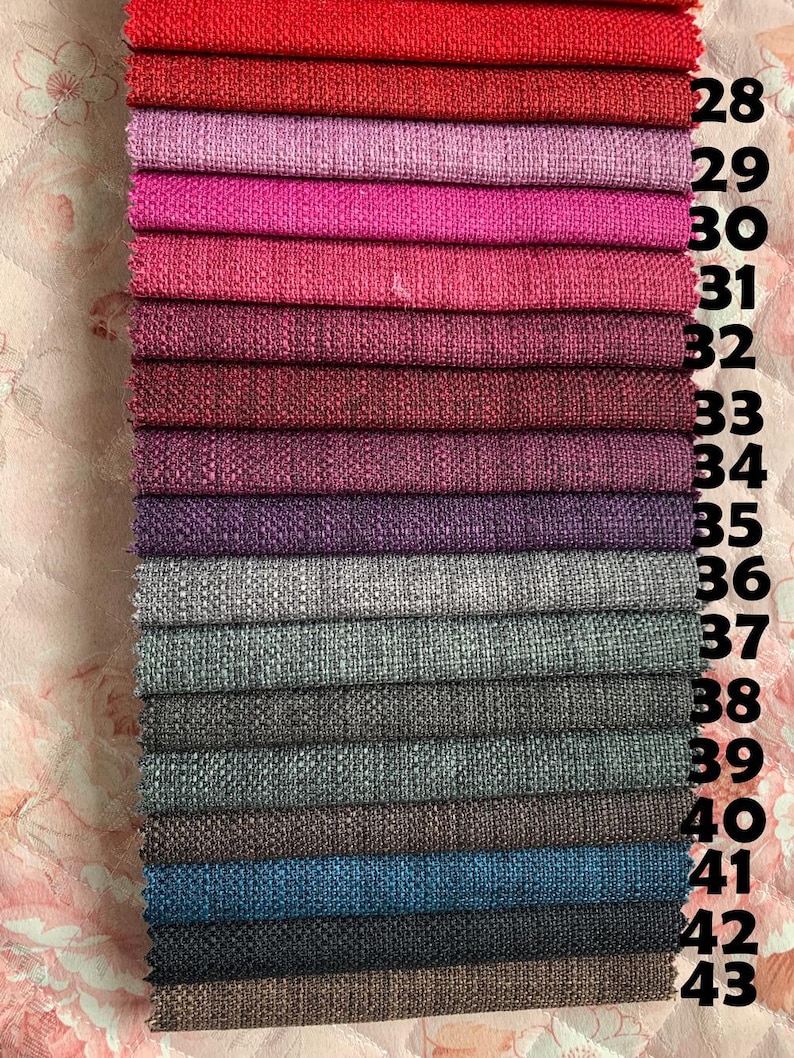 May include: A swatch card with 16 different fabric samples in various shades of red, pink, purple, gray, blue, and brown. The swatches are numbered 28 through 43.