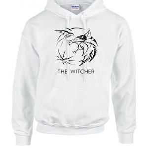 K&ouml;nnte beinhalten: Wei&szlig;er Kapuzenpullover mit einem schwarzen Aufdruck eines Wolfskopfes mit einem Schwert und dem Text "THE WITCHER" auf der Vorderseite.