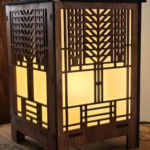 May include: A wooden lamp with a geometric design inspired by a tree of life. The lamp has a warm, yellow glow emanating from the inside.