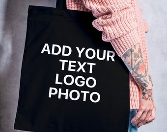 May include: A black tote bag with white text that says "ADD YOUR TEXT LOGO PHOTO".
