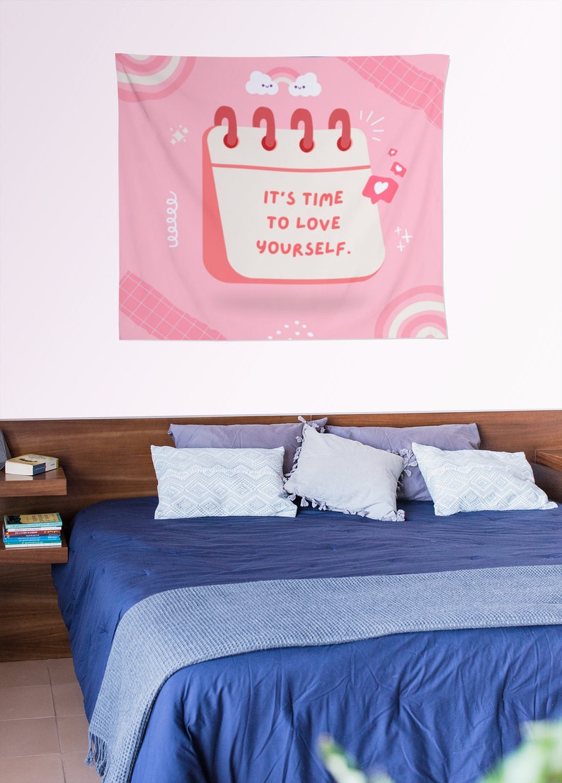 May include: Pink tapestry with a calendar design that says "It's time to love yourself." The calendar has a pink background and white text. There are also pink and white clouds, hearts, and stars on the tapestry.