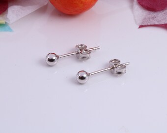 May include: A pair of silver stud earrings with small round balls. The earrings have a simple and elegant design.