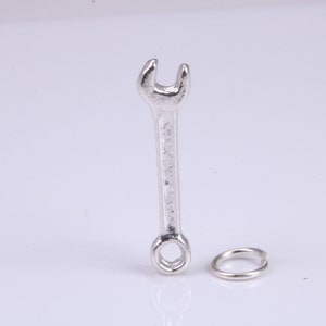 May include: A silver wrench charm with a silver jump ring.