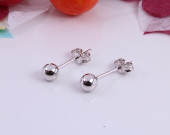 May include: A pair of silver stud earrings with round balls. The earrings have a post and butterfly back.
