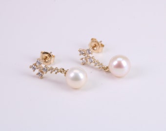 May include: A pair of gold earrings with a pearl drop and a sparkling crystal design.