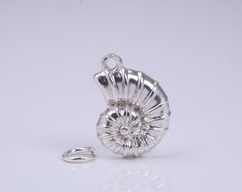 Pode incluir: Um amuleto de prata em forma de concha de nautilus. O amuleto tem um design detalhado e um laço para prender a um bracelete ou colar.