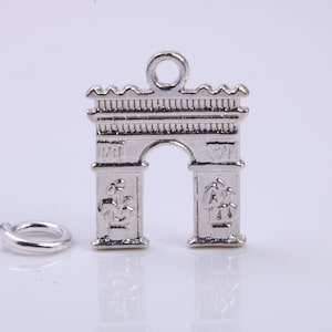 May include: Silver charm shaped like the Arc de Triomphe in Paris, France. The charm has a loop at the top for attaching to a bracelet or necklace.