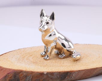 Miniaturowa figurka siedzącego owczarka niemieckiego, wykonana z odlewu srebra próby 925 z brytyjską cechą probierczą