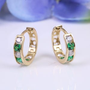 10 mm round hinged hoop earrings, made from solid yellow gold and set with Emerald and Diamond Cubic Zirconia