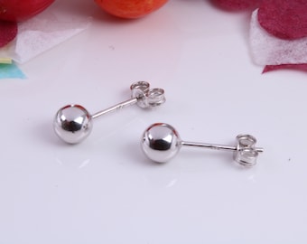 May include: A pair of silver stud earrings with round balls. The earrings have a post and butterfly back.