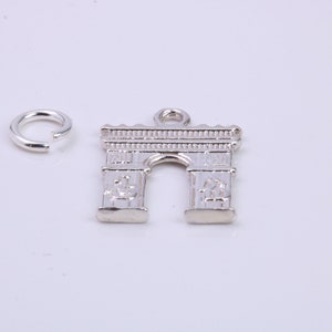May include: Silver charm in the shape of an archway, with a small jump ring attached.