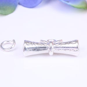 Dije de graduación, dije tradicional tridimensional, elaborado en plata maciza fundida