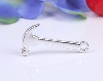 May include: A silver-colored hammer charm with a loop for attaching to a bracelet or necklace.