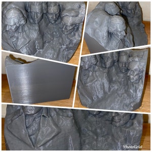 May include: A 3D printed sculpture of a group of people's faces. The sculpture is made of a gray material and has a textured surface.