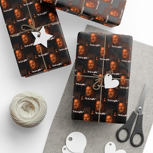 May include: Gift wrap featuring a repeating pattern of a man's face with the text "It is a gift." The wrapped gifts are tied with twine and adorned with decorative tags. A ball of twine and scissors are also present.