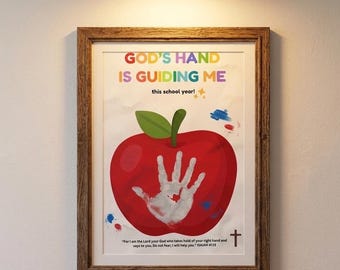 May include: A framed wall art print featuring a large red apple with a white handprint in the center. The text reads: GOD'S HAND IS GUIDING ME this school year! and includes the Bible verse: For I am the Lord your God who takes hold of your right hand and says to you. Do not fear; I will help you. ISAIAH 41:13.