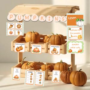 May include: A wooden pumpkin stand with various sizes of pumpkins displayed in wooden crates. Signs indicate "medium pumpkins," "large pumpkins," and "small pumpkins." Additional signs read "pumpkin patch cafe" and "welcome to the pumpkin patch."
