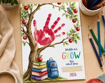 May include: A printed card featuring a watercolor tree with a red handprint in the center, a stack of colorful books, and a blue backpack. The text reads: Watch me GROW this school year, First day of school, 2026. The design includes red apples.