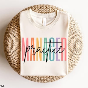 May include: A white t-shirt with the text "Manager Practice" in rainbow colors. The text is in a bold, handwritten font.