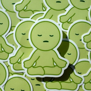 May include: A collection of green stickers featuring a cartoon character meditating with closed eyes. The character has a round head and a simple body with arms and legs.