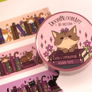 May include: A pink and purple washi tape roll featuring a cat sitting on a stack of books. The tape is labelled "Doombloomart - 10 metres - Cats x Literature Washi Tape".