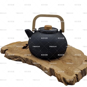 Könnte beinhalten: Eine schwarze Gusseisen-Teekanne mit Holzgriff und Deckelknopf steht auf einer Naturholzplatte. Die Teekanne hat einen runden Körper und einen Ausguss. Die Holzplatte hat eine organische Form.