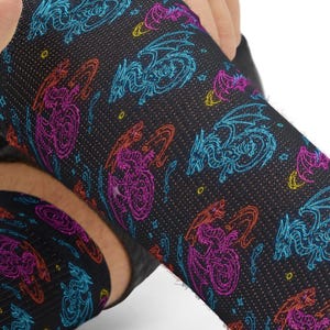 May include: Black socks with a repeating pattern of colorful dragons in blue, purple, and red. The socks are being pulled up, showing the design on the leg.