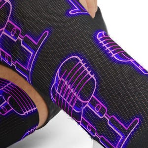 Puede incluir: Calcetines negros hasta la rodilla con un diseño repetido de micrófonos morados neón. Los calcetines muestran un diseño repetido de micrófonos vintage. El diseño morado brillante contrasta con la tela negra.