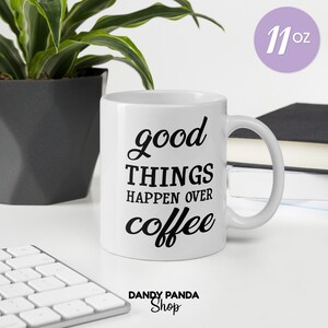Könnte beinhalten: Weiße Keramik-Kaffeetasse mit dem Text "good THINGS happen over coffee" in schwarzer Schrift. Die Tasse hat ein Fassungsvermögen von 325 ml und einen gebogenen Henkel. Das Logo von Dandy Panda Shop befindet sich unten.