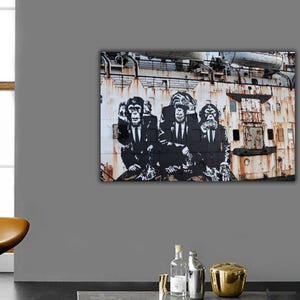 May include: Three black and white chimpanzees wearing suits and ties are painted on a rusty metal wall. The chimpanzees are covering their eyes, ears, and mouth. The image is a street art style piece.