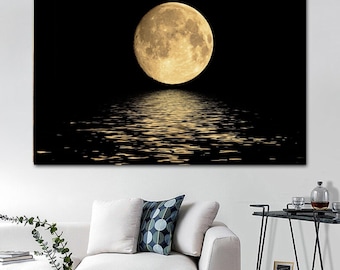 May include: A rectangular wall art print featuring a large, luminous full moon centered against a solid black background, with the golden light of the moon reflecting across the surface of dark, rippling water below the celestial sphere.