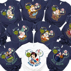 May include: Ten navy blue and white t-shirts with a Disney Snow White theme. Each shirt features a different character from the movie, including Snow White, the Evil Queen, Doc, Grumpy, Happy, Sleepy, Bashful, Sneezy, Dopey, and the Evil Witch. The shirts are all decorated with a Mickey Mouse ear silhouette and a stylised apple.