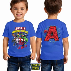 May include: A royal blue t-shirt featuring a graphic print of various superhero characters and the text Austin and his Amazing Friends on the front, and a large red letter A with a spiderweb pattern on the back of the garment.