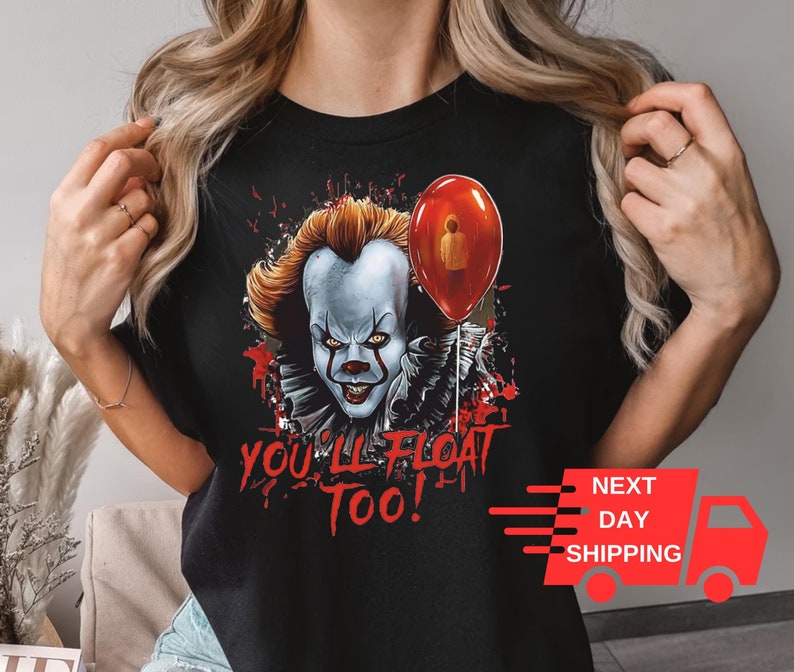 May include: Black t-shirt with a graphic of Pennywise the clown from the movie "IT" holding a red balloon. The text "You'll Float Too!" is printed below the graphic.