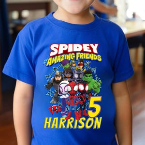 Puede incluir: Camiseta azul con el texto "Spidey and his Amazing Friends" y un gr&aacute;fico de los personajes. El n&uacute;mero "5" y el nombre "Harrison" son de color amarillo. La camiseta est&aacute; hecha de un material suave y es adecuada para ni&ntilde;os.