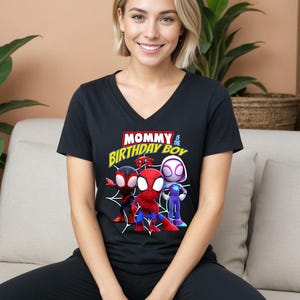 Puede incluir: Camiseta negra de cuello en V con un gr&aacute;fico de personajes de Spider-Man. El texto "Mommy of the Birthday Boy" est&aacute; impreso en amarillo en la camiseta.