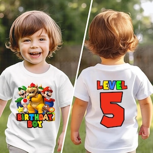 May include: White t-shirt with a colorful Mario character graphic on the front and the text "Birthday Boy". The back of the shirt has the text "Level 5" in colorful letters.