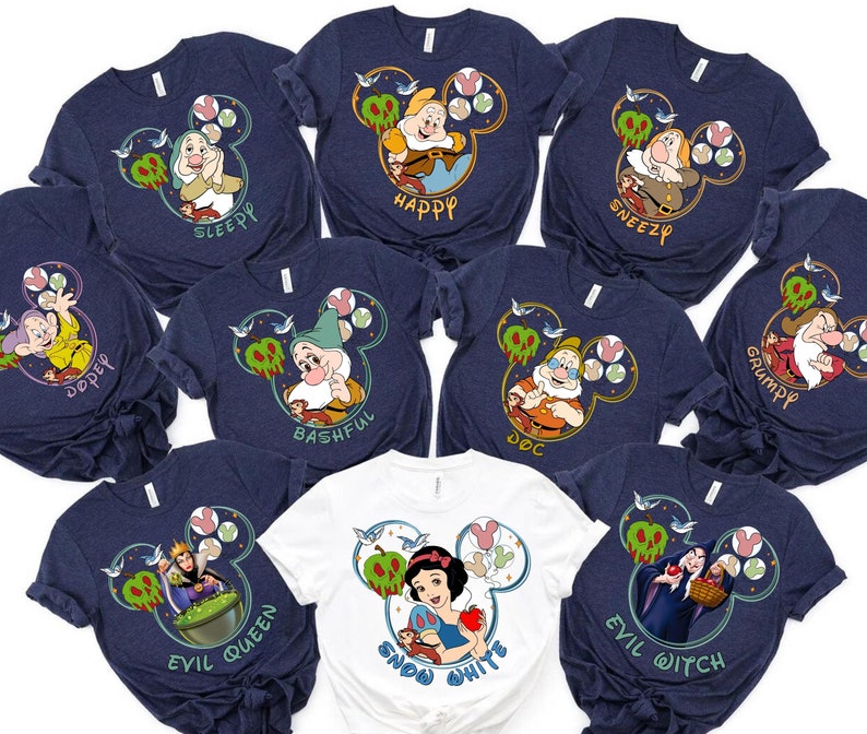 May include: Ten navy blue and white t-shirts with a Disney Snow White theme. Each shirt features a different character from the movie, including Snow White, the Evil Queen, Doc, Grumpy, Happy, Sleepy, Bashful, Sneezy, Dopey, and the Evil Witch. The shirts are all decorated with a Mickey Mouse ear silhouette and a stylised apple.