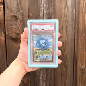 May include: A PSA graded 2024 Pokemon Mew ex Special Illustration Rare trading card, number 232, with a Mint 9 rating. The card is encased in a clear plastic slab with a light blue frame, displaying the character Mew in a blue circle.