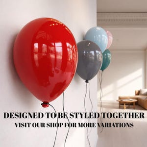 May include: A collection of glossy, round balloons in red, grey, light blue, teal, and soft pink, attached to thin black strings. The text "DESIGNED TO BE STYLED TOGETHER VISIT OUR SHOP FOR MORE VARIATIONS" is printed in black at the bottom.