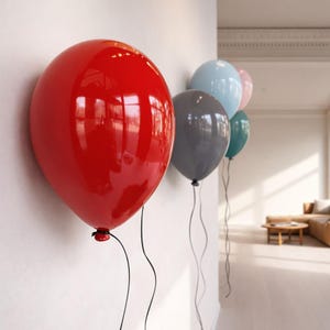 May include: A series of five glossy, rounded balloon-shaped wall decorations mounted in a row. The balloons are colored red, light blue, dark gray, teal, and pale pink, each featuring a thin black string hanging down from the bottom knot.