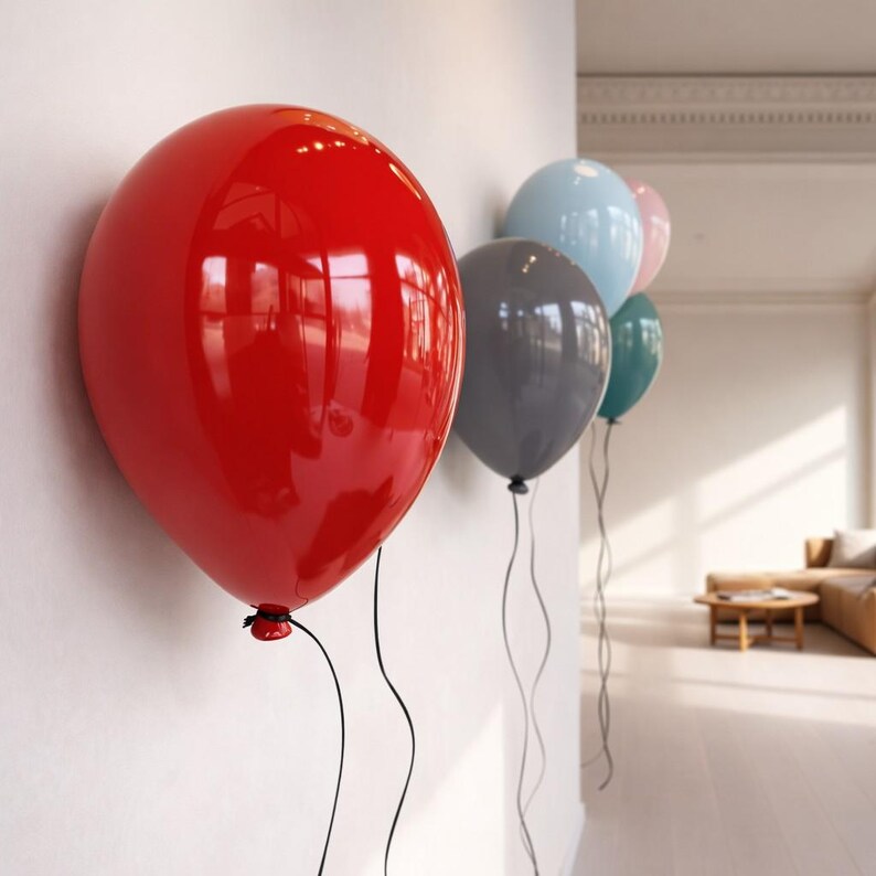 May include: A series of five glossy, rounded balloon-shaped wall decorations mounted in a row. The balloons are colored red, light blue, dark gray, teal, and pale pink, each featuring a thin black string hanging down from the bottom knot.