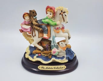 The Natalia Collection Child On A Rocking Horse With Toys Sculpture Figurine