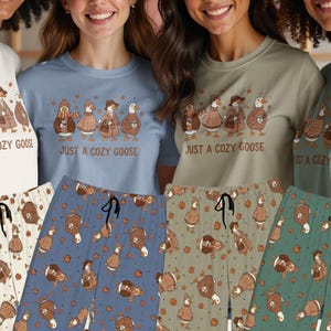 Peut inclure: Quatre t-shirts et pantalons de pyjama assortis en blanc, bleu, beige et vert. Chaque t-shirt présente un motif de quatre oies portant des pulls et des chapeaux avec le texte "JUST A COZY GOOSE". Le pantalon a un motif répété d'oies et de feuilles d'automne.