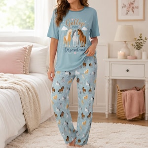 May include: A light blue pyjama set consisting of a short-sleeved t-shirt and matching trousers. The shirt features three horses and the text "Gallop into Dreamland." The trousers are covered in a repeating pattern of various horses in different colours.