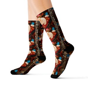 May include: A pair of knee-high socks with a festive Christmas pattern. The socks feature a repeating design of Santa Claus, blue mittens, and decorative elements on a dark red background. The socks have black heels and toes.