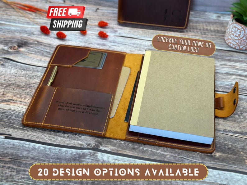 May include: A brown leather journal with a pen holder and a pocket for a card. The journal has a quote engraved on the front and a blank page inside. The journal is open and the pages are blank. The journal is on a wooden surface. "Proud of all your accomplishments thus far and excited for all the great things you'll do ahead." 20 DESIGN OPTIONS AVAILABLE